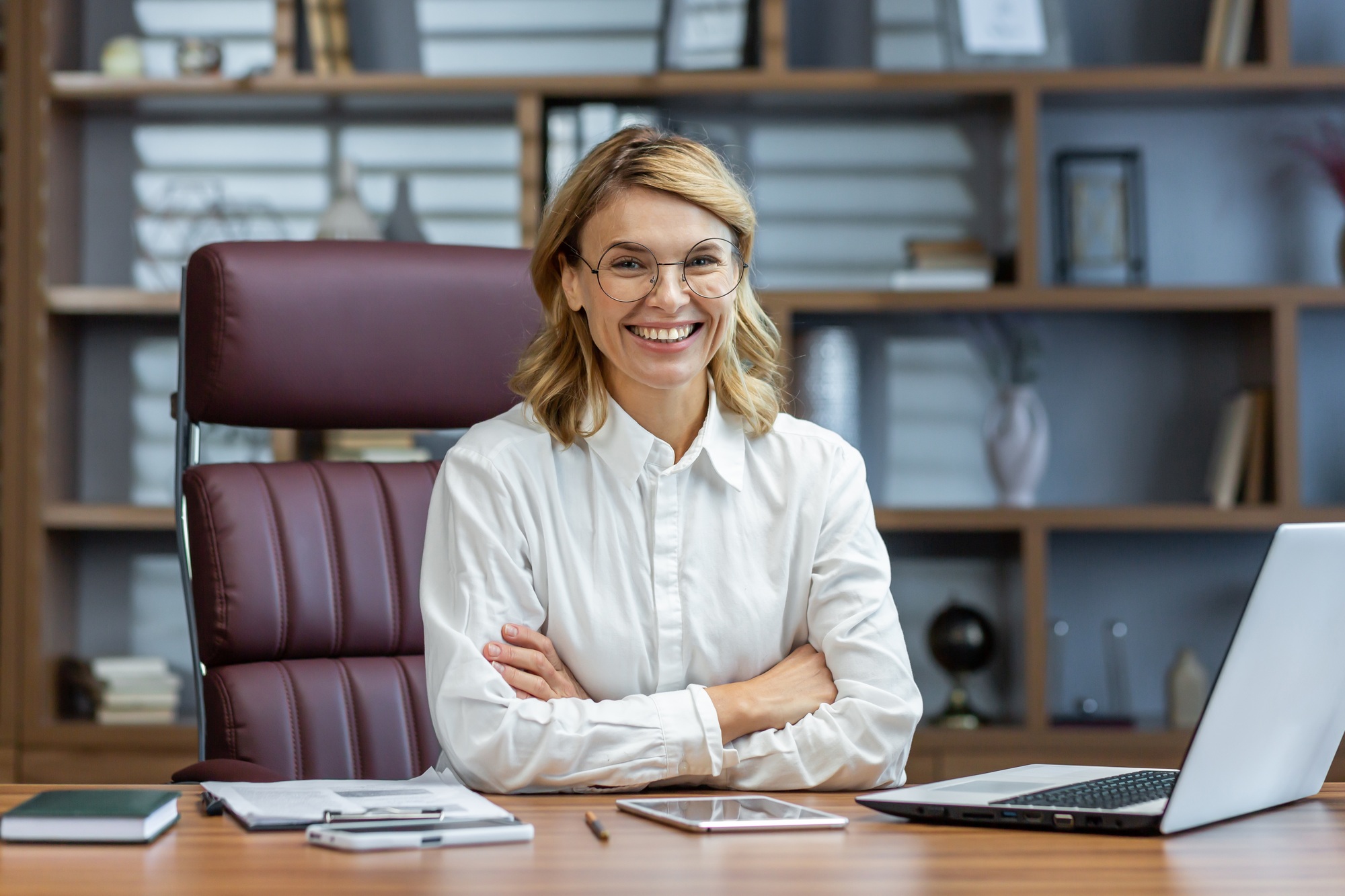 Portrait of an older beautiful blonde woman, director, boss, founder of the company in glasses and