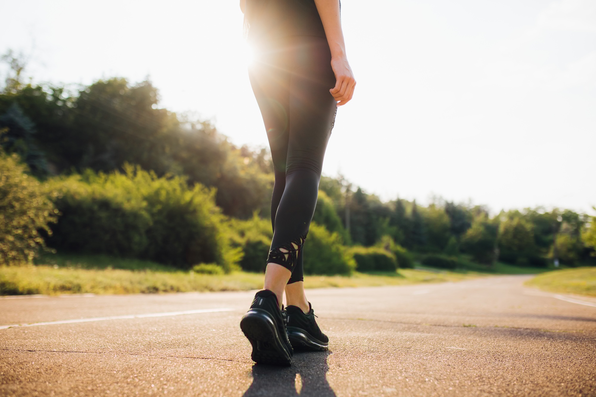 close up, young fitness woman legs walking at the street